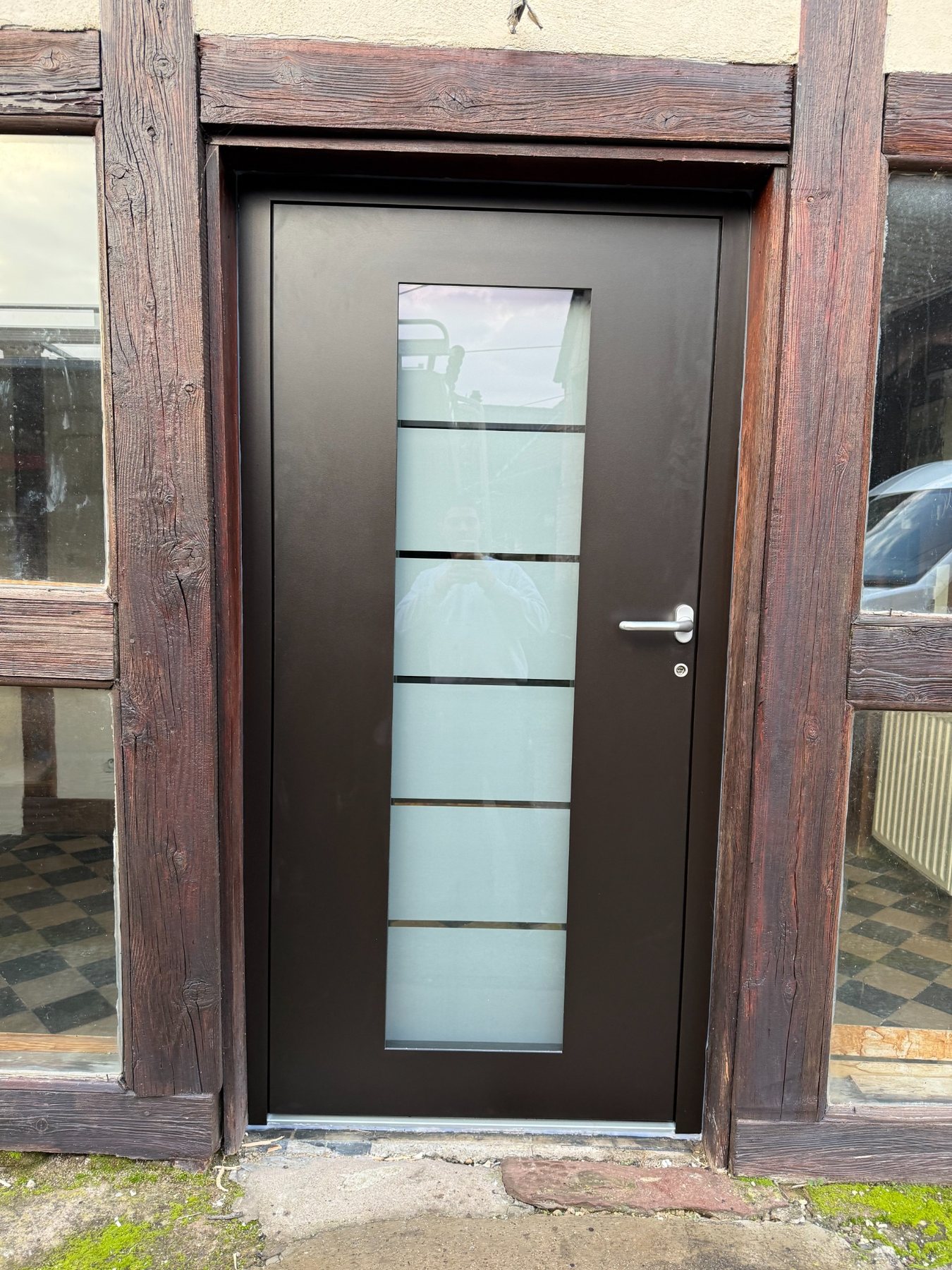 Porte d'entrée noire avec vitrage vertical